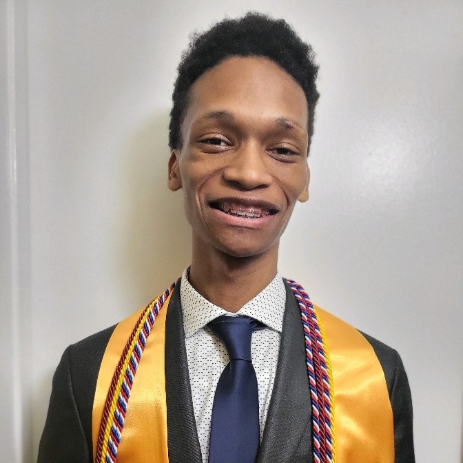 headshot of Denzel Johnson smiling, wearing a tie and a black graduation gown with a yellow honors stole